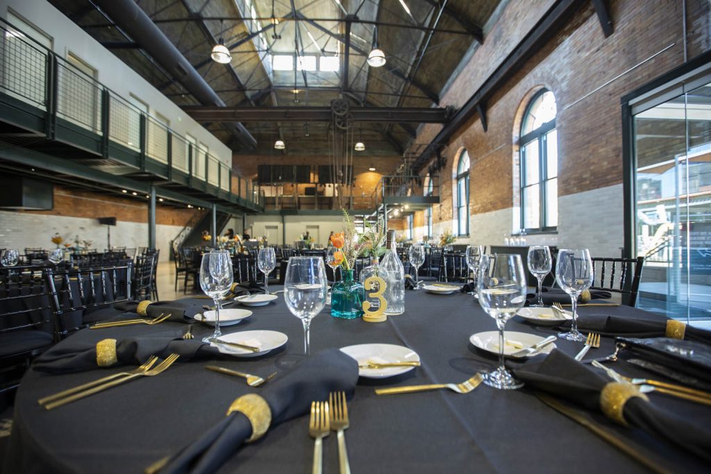 Black and gold table settings in the main space of The Stack at Municipal Light Plant.