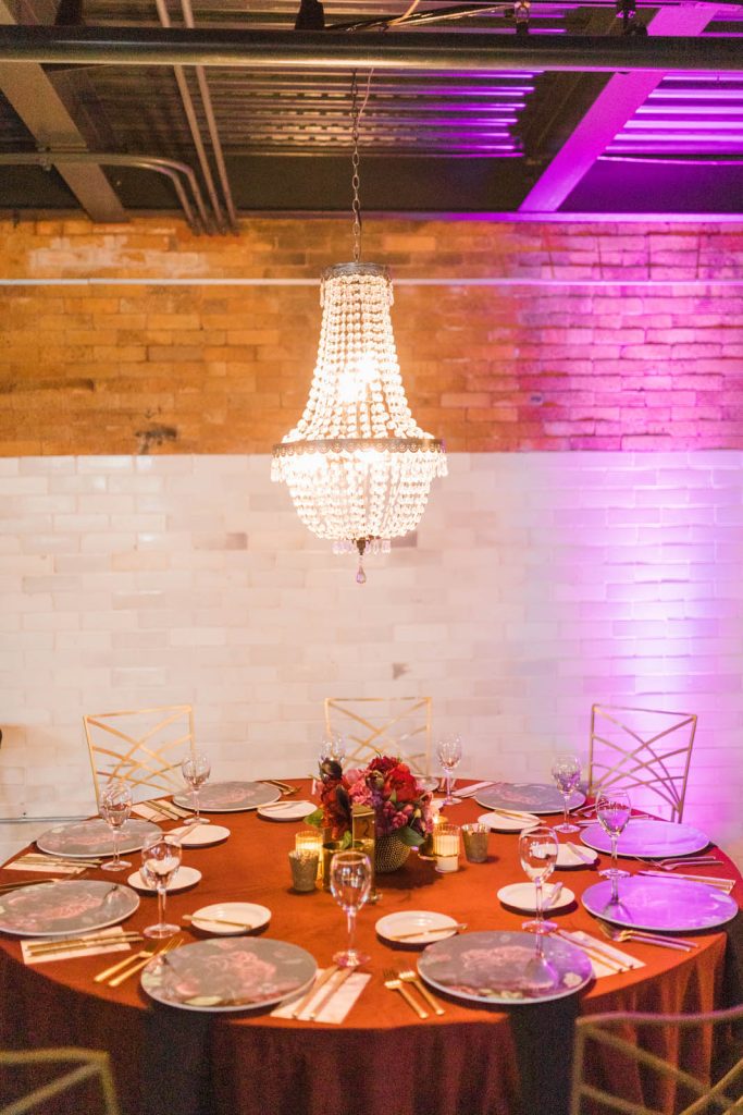 Rented chandelier hanging over elegant rustic table setting at The Stack at Municipal Light Plant.