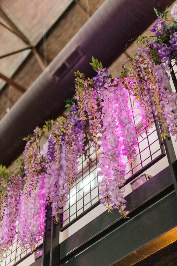 Wisteria and purple florals hanging from rails across the private suites on the lofts of The Stack at Municipal Light Plant.